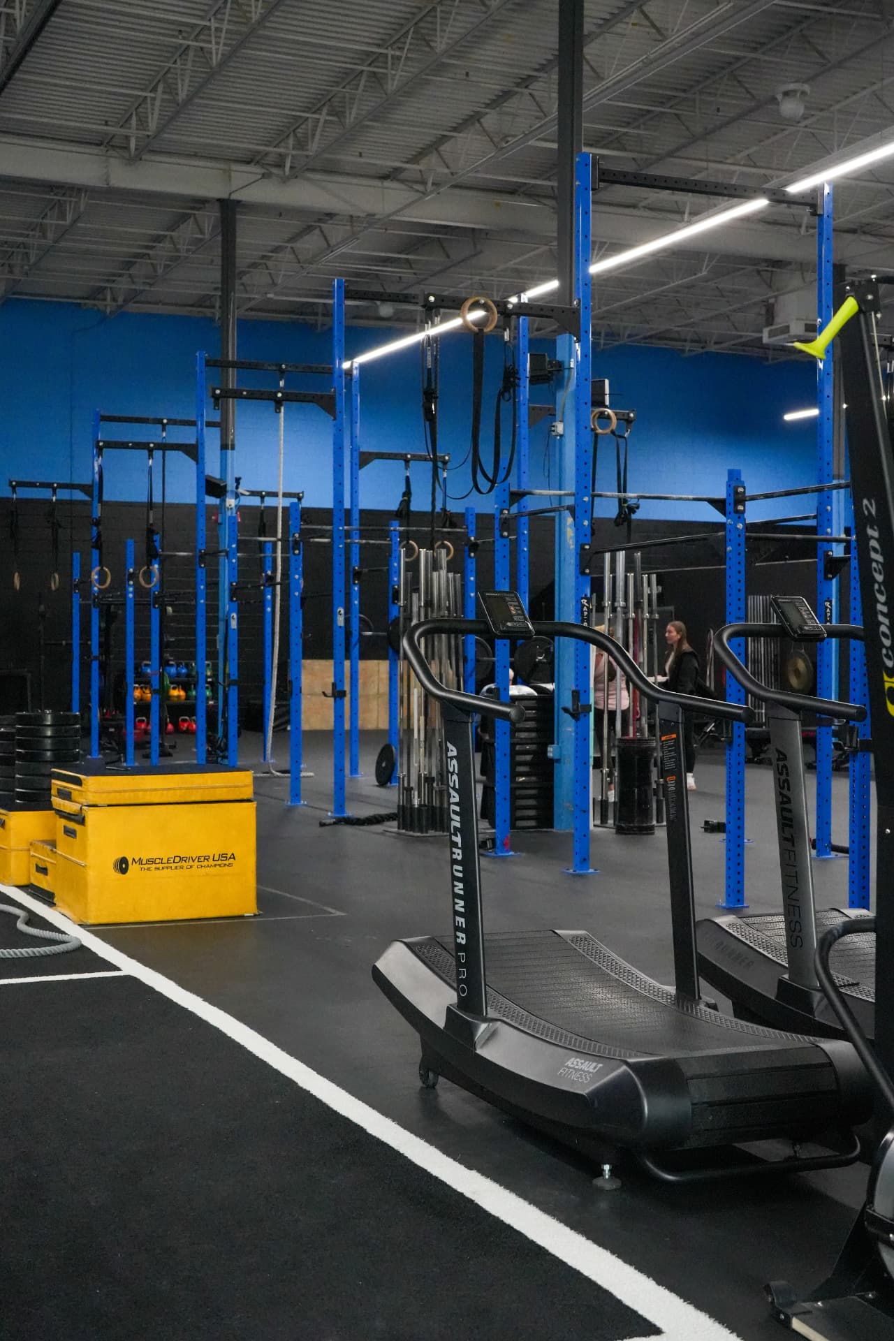 Training floor at Arsenal Health Arvada with squat racks, curved treadmills and plyo boxes
