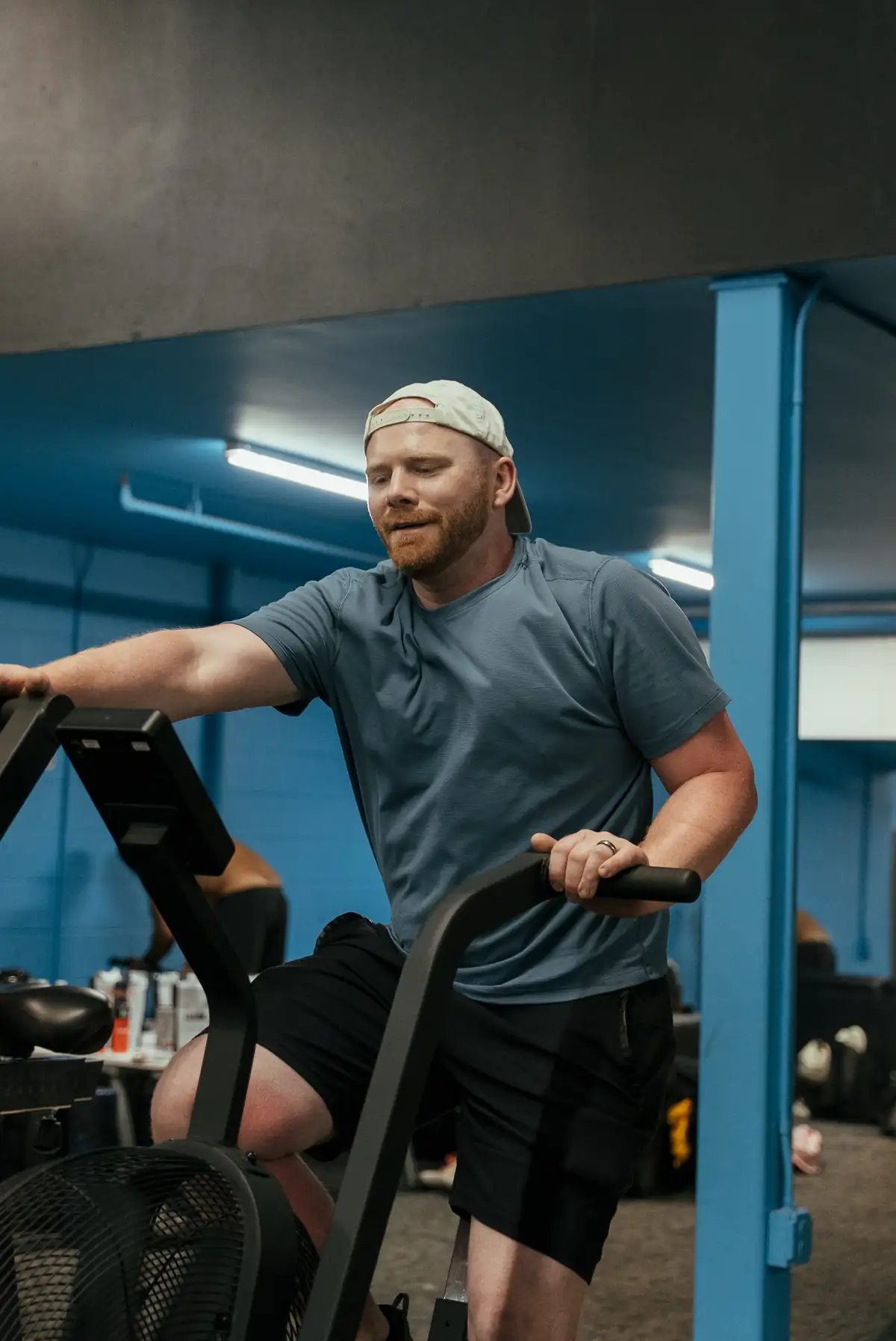 Arsenal Health male member demonstrating strength and power during air bike training